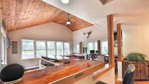 Une cuisine spacieuse avec un plafond en bois, de grandes fenêtres et un coin bar.