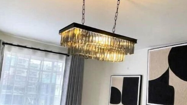 A modern living room with a beige sectional sofa, a decorative chandelier, and abstract wall art. - Cozy 1BR Near Two Rivers & UN | Fast Wi-Fi (Nairobi)