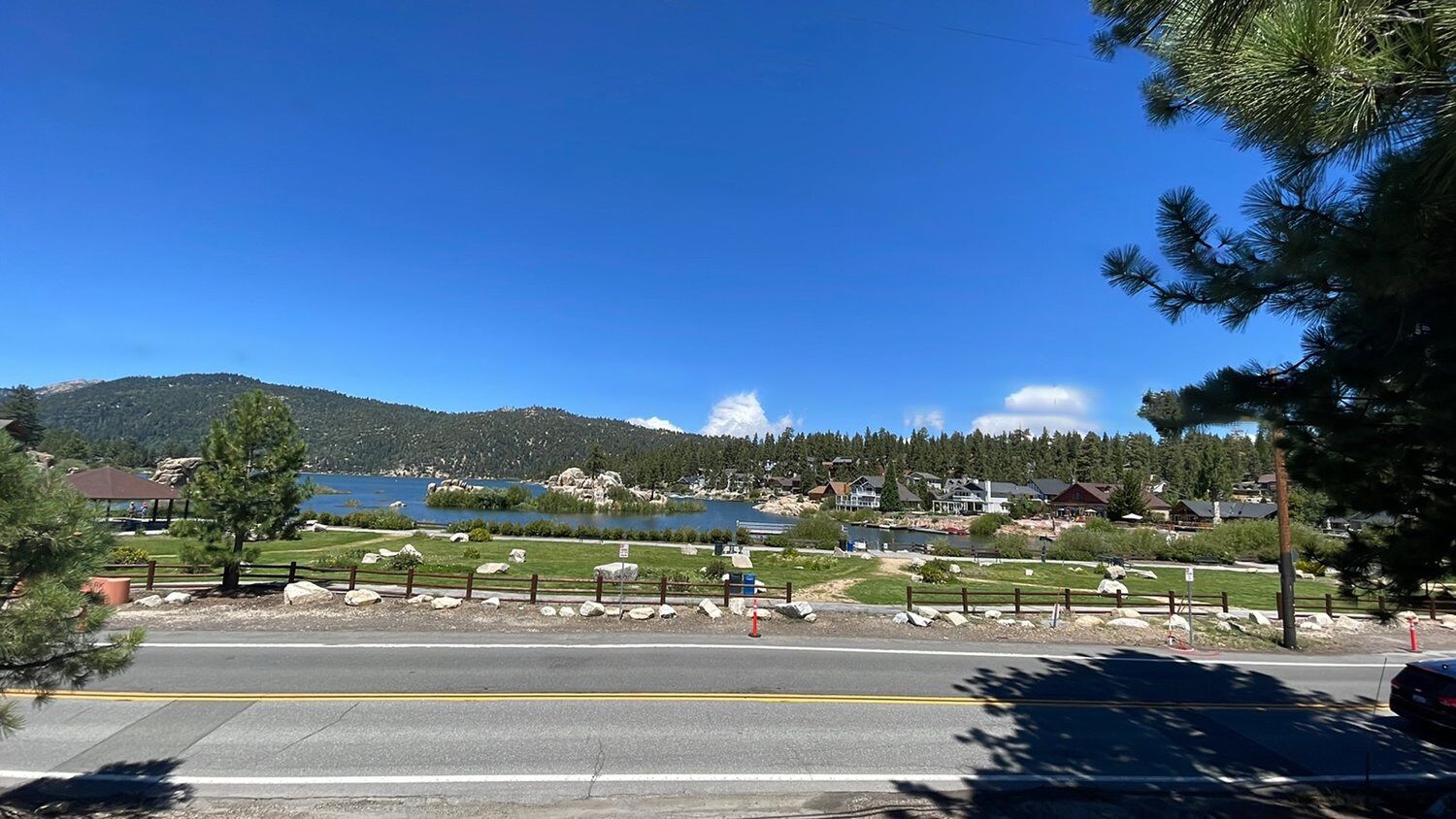 Une route offrant une vue dégagée sur un lac et des montagnes en arrière-plan.