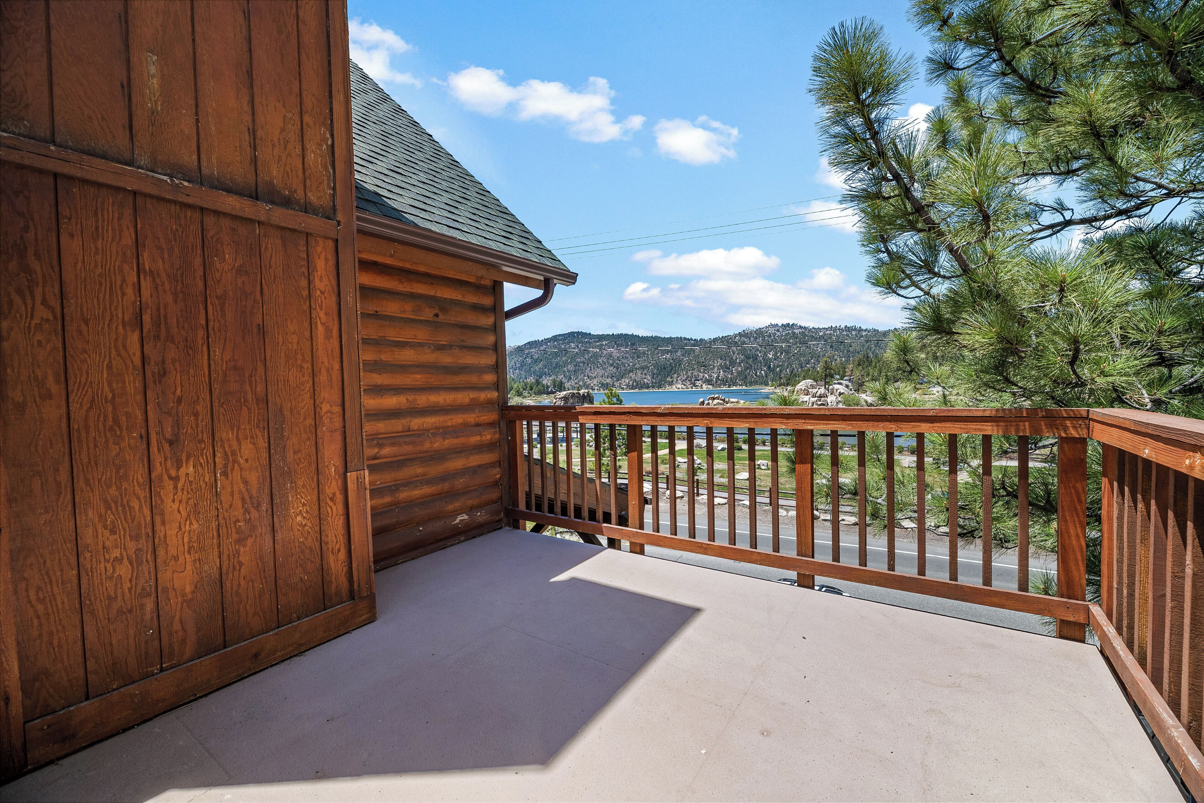 Eine Holzhütte mit einem Balkon mit Blick auf einen See und Berge.