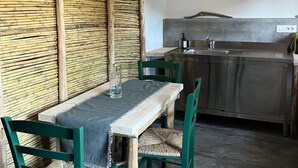 Un comedor con mesa y sillas de madera, una encimera de cocina y un panel decorativo en la pared.