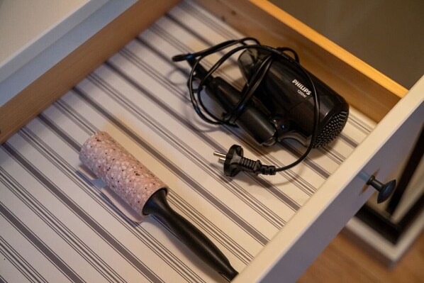 Un tiroir contenant un tire-bouchon et un adaptateur secteur Philips.