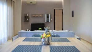 Une chambre d’hôtel moderne dotée d’un coin repas, d’une télévision à écran plat et d’un minibar.