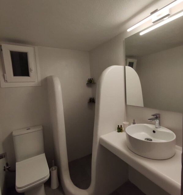 A modern bathroom with a toilet, a sink, and a mirror. - Theis Seafront Retreat - Loutra Seaview Bliss (Kithnos)
