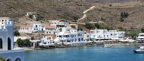 A coastal town with white buildings, a church, and a marina with boats.