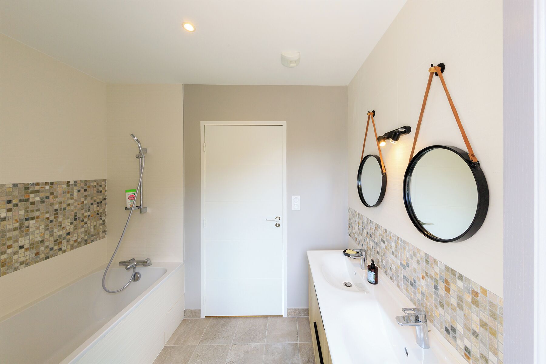 Un baño moderno con bañera, dos lavamanos y ducha.
