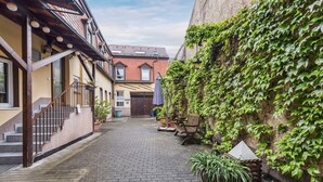A narrow cobblestone alley with a staircase leading to a building with a tiled roof. - Hotel zum Erwin (Karlsruhe)