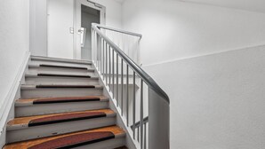 A staircase with white walls and a metal railing. - Hotel zum Erwin (Karlsruhe)
