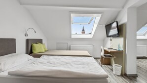 A modern, well-lit bedroom with two beds, a desk, a TV, and a skylight. - Hotel zum Erwin (Karlsruhe)