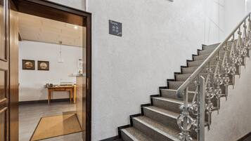 A staircase with a metal handrail and a sign indicating room availability.