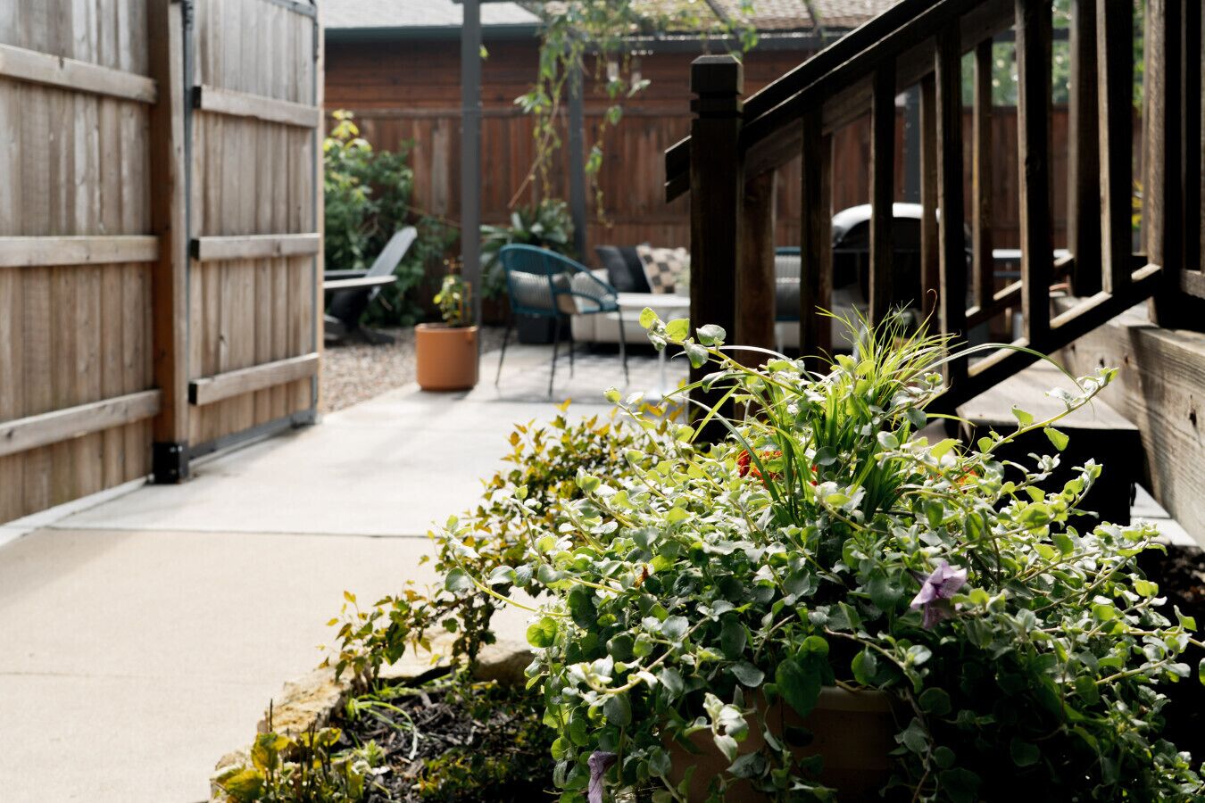 A garden area with potted plants and a wooden fence.