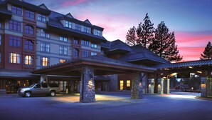 A multi-story hotel with a covered entrance and stone pillars.