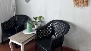 A cozy room with two black chairs, a small white table, and a green plant. - Camping 2000 - Glamourtent (Osecná)