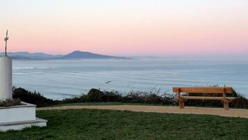Un banc offrant une vue sur la côte, avec un monument au premier plan.