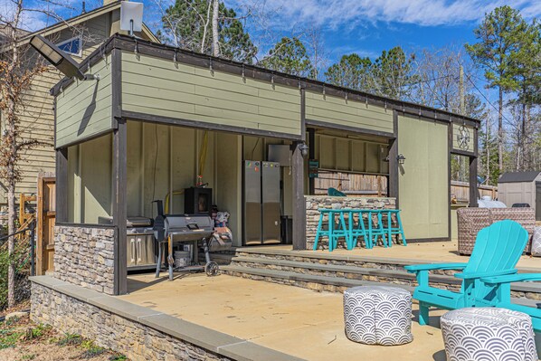 A covered outdoor patio with stone steps, a grill, and outdoor seating. - Tranquil Getaway Minutes from Auburn including Pool & backyard Waterfall Oasis (Salem)