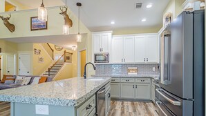 A kitchen with granite countertops, stainless steel appliances, and wooden flooring. - Tranquil Getaway Minutes from Auburn including Pool & backyard Waterfall Oasis (Salem)