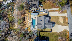 An aerial view of a residential property with a swimming pool, a covered patio, and a driveway leading to a garage. - Tranquil Getaway Minutes from Auburn including Pool & backyard Waterfall Oasis (Salem)