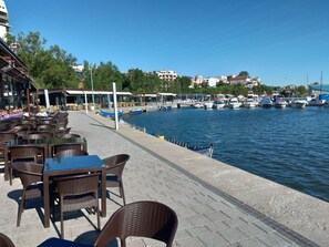A waterfront café with outdoor seating and a view of the marina.