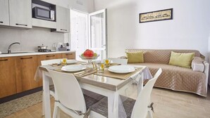 A compact living space with a kitchenette, dining area, and a sofa.