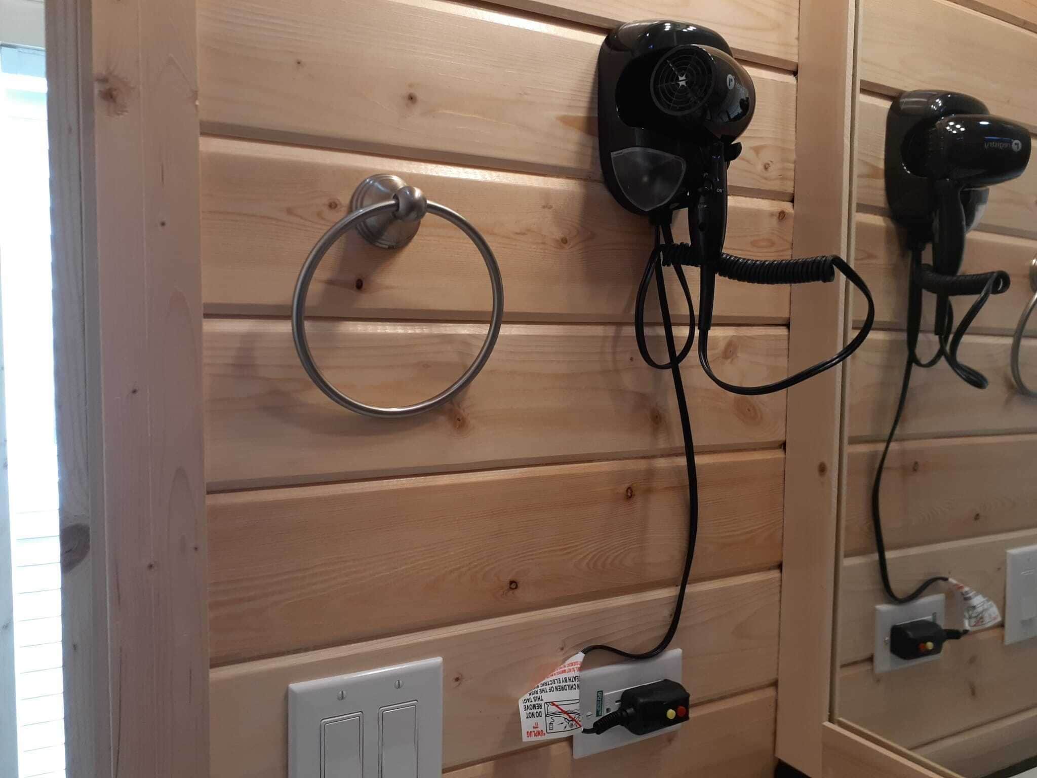 Pared de madera con un secador de pelo y un anillo.