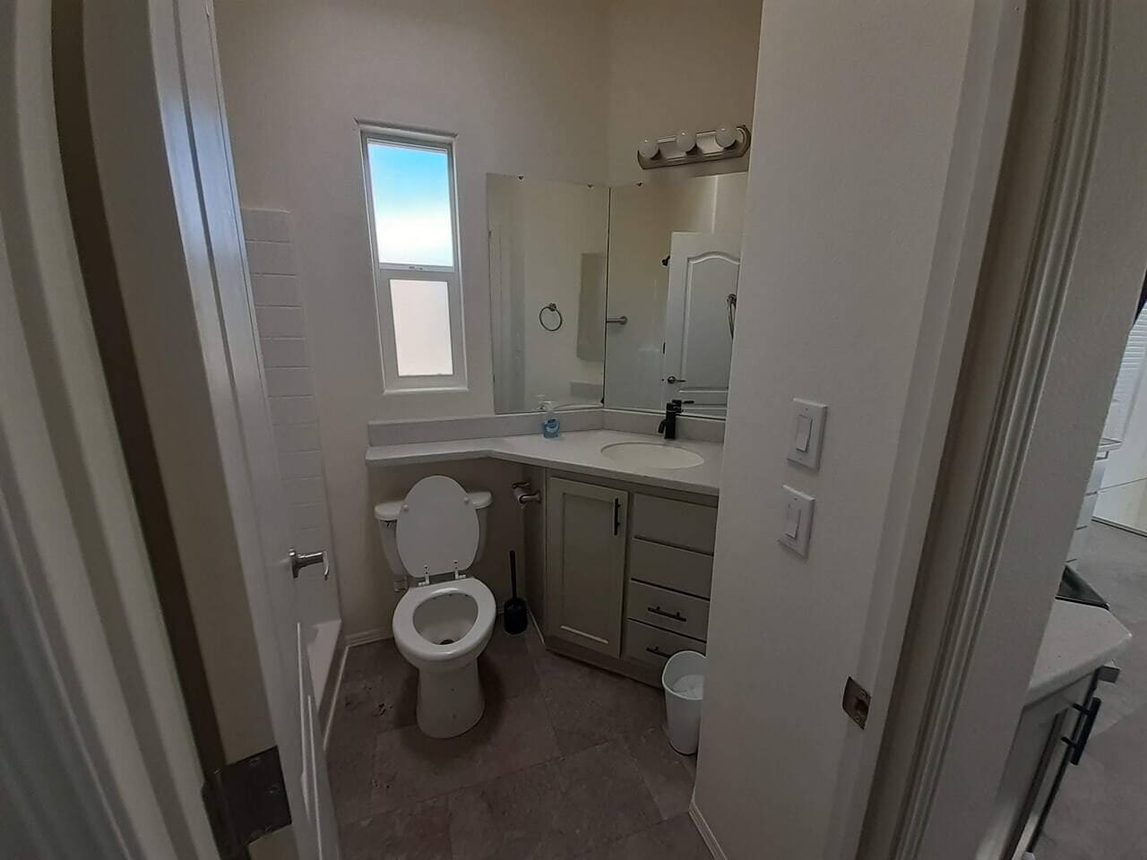 Un bagno compatto con servizi igienici, lavandino e specchio.
