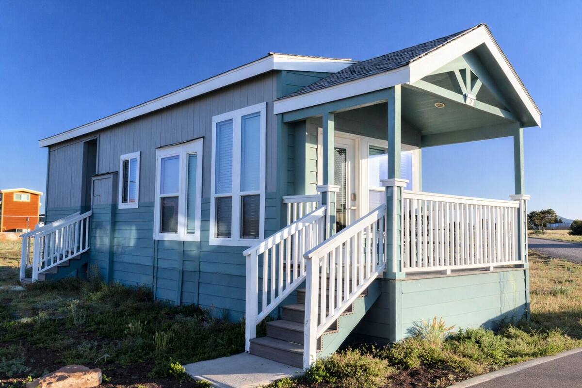 A small, single-story building with a porch and a staircase.