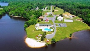 An aerial view of a lakeside property with a swimming pool, a red barn, and a large house. - Wilderness Presidential Resort 2 Bedroom 2 Bathroom 1200 sq ft Log Cabin (Spotsylvania Courthouse)