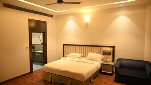A hotel room with a bed, bedside table, lamp, and a ceiling fan.