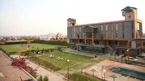 A modern hotel with a central courtyard, a swimming pool, and a staircase leading to the upper levels.
