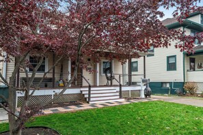 A two-story house with a front porch, a small tree with red leaves, and a checkered pathway leading to the entrance. - Walk to Metro-Near Washington DC-Amazon HQ-DCA Airport-Pentagon-Crystal City (Arlington)