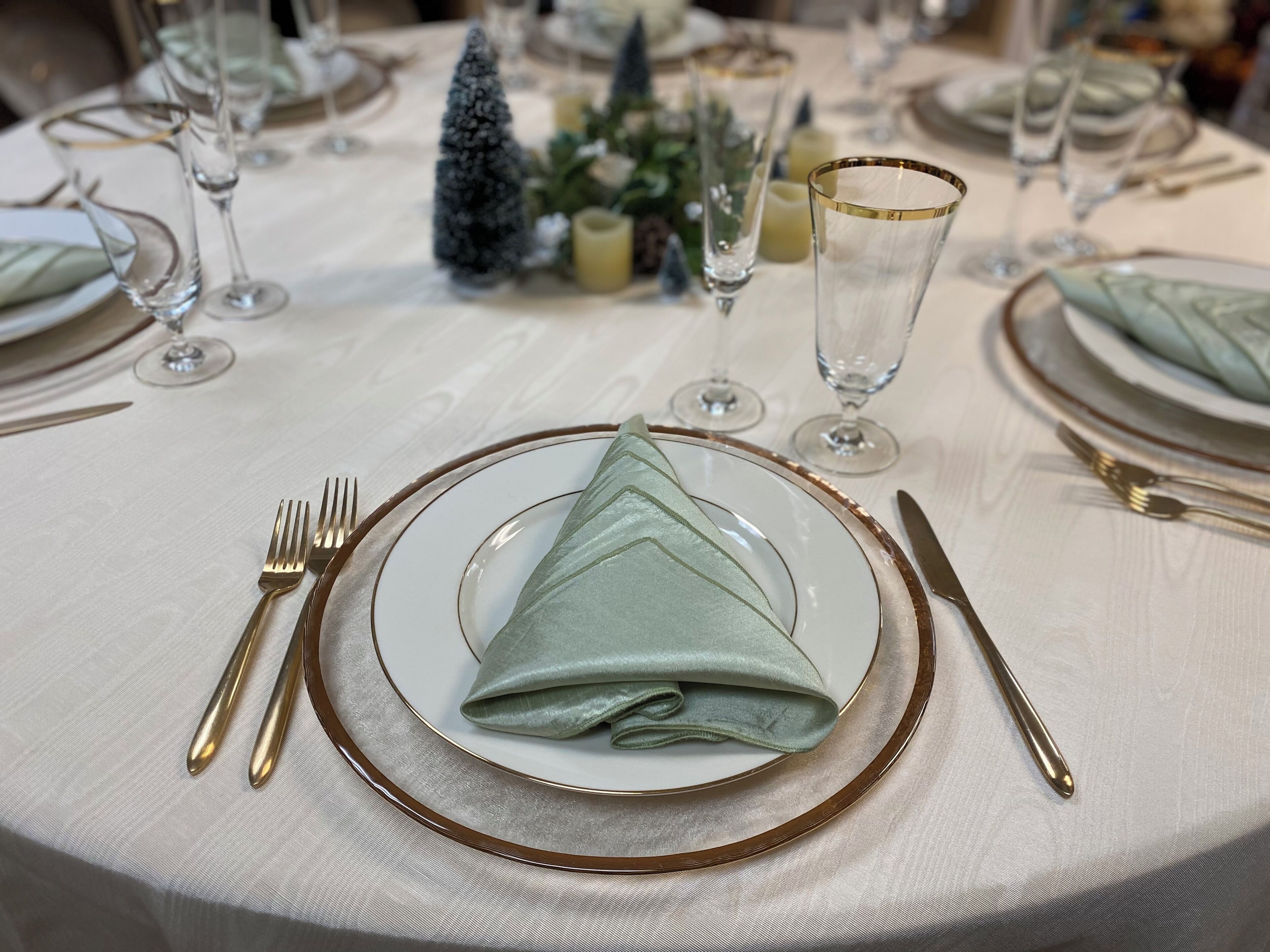 Mesa dispuesta para una ocasión de cena formal, con servilleta doblada, cubiertos y cristalería.