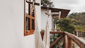 Ein Balkon mit Holzwertkasten, einer weißen Wand und einem Fenster mit Holzrahmen.