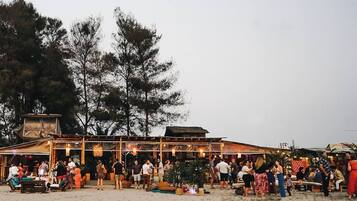 Ein Restaurant am Strand mit Außenbereich, umgeben von Bäumen.