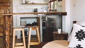 A cozy kitchen with wooden stools, a stove, and a dining area.