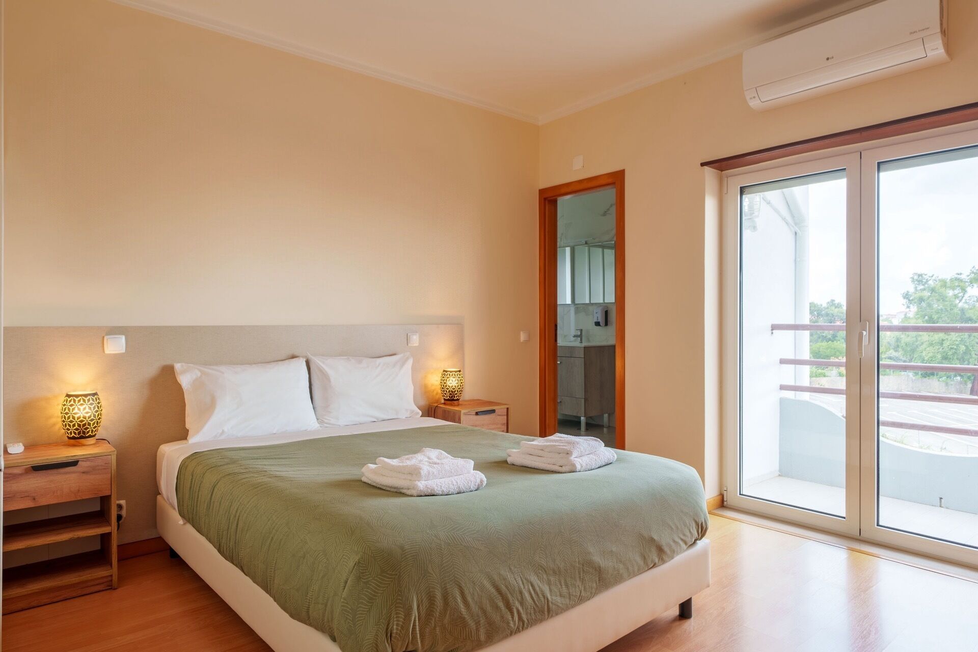 Une chambre d’hôtel équipée d’un lit, de lampes de chevet, d’une fenêtre et d’un appareil de climatisation.