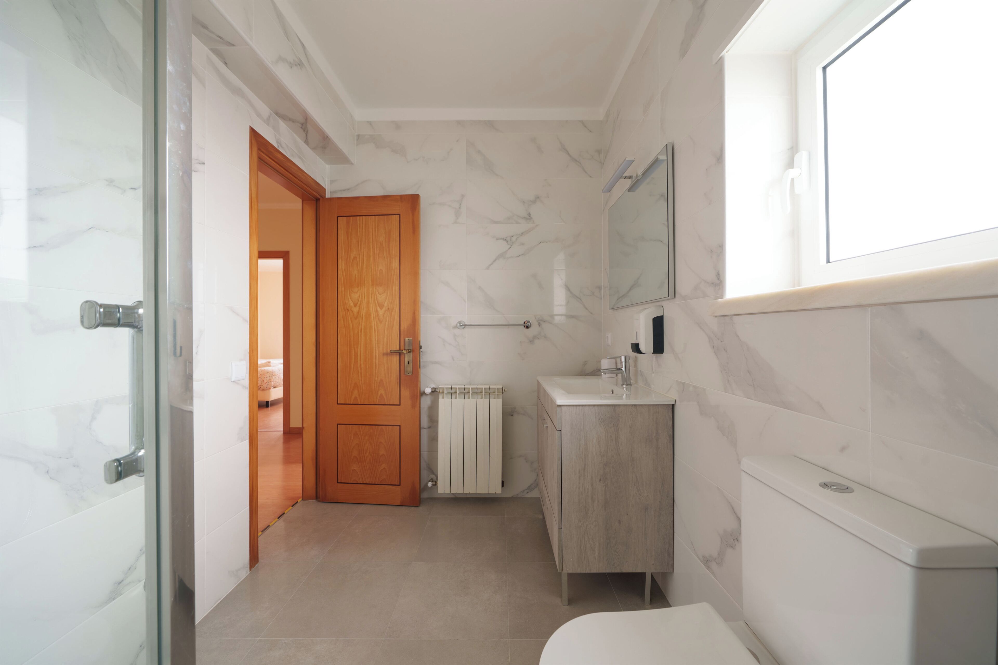 Un baño con inodoro, lavamanos y zona de ducha.