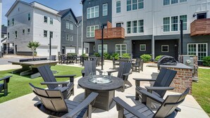 A patio area with Adirondack chairs, a round table, and a fire pit. - #StokeHotel: Boho Outdoorsy Vibes, Paddleboards, Kayak, Dog Park (Chattanooga)