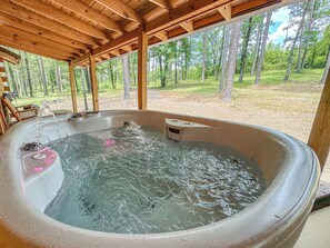 A hot tub with water flowing, surrounded by a wooden pergola and a forest view. - Luxury Retreat, Private Hot Tub, Romantic Getaway (Bismarck)