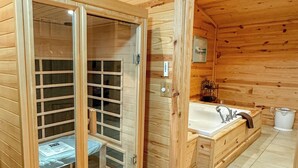 Een houten cabin met een houten garderobe, een ingebouwde bank en een houten bad.