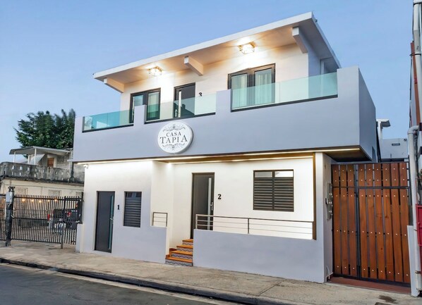 Un bâtiment moderne à deux étages, sur lequel on peut lire l’inscription « CASA TAPIA ».