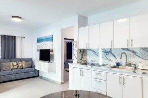 A modern kitchen with white cabinets, a marble countertop, and a built-in sink. - Modern San Juan Apt w/ Parking Near Ocean Park (San Juan)