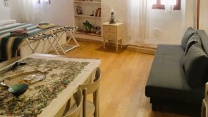 A cozy living room with a dining area, wooden beams on the ceiling, a sofa, a table with a tablecloth, and a lamp. - "Lovely Home" Cozy Bike Friendly Holiday Home with Wi Fi (Buonconvento)