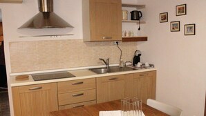 A compact kitchen with wooden cabinets, a stainless steel sink, and a coffee maker. - "Lovely Home" Cozy Bike Friendly Holiday Home with Wi Fi (Buonconvento)