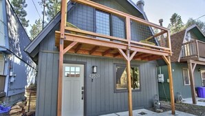 A two-story house with a grey exterior, a wooden porch, and a visible number 42539 on the front door. - Brooklyn Cabins (Big Bear Lake)