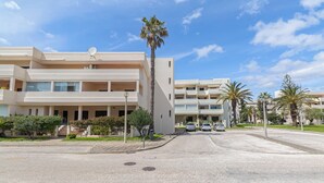 A modern multi-story building with balconies, palm trees, and a clear sky. - Huniky 35 - Sea view, Wifi and air conditioning (Lagos)