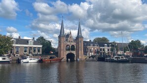 A historic bridge with two towers, a canal with boats, and buildings with traditional architecture. - Vacation home near the beach and the cities of Amsterdam and Haarlem. (Beverwijk)