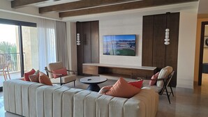 A modern living room with a large sofa, two armchairs, a coffee table, and a TV mounted on the wall. - Cabo San Lucas - Thanksgiving week !! - 2 bdrm penthouse - Grand Solmar Resort (Cabo San Lucas)