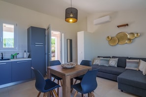 Une cuisine moderne avec un coin repas, un canapé et un élément décoratif mural.