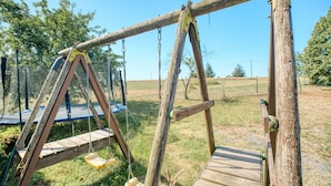Un conjunto de columpios de madera en un área verde.