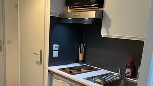Une cuisine compacte équipée d’un four à micro-ondes, d’une cuisinière, d’un évier et d’un lave-vaisselle.